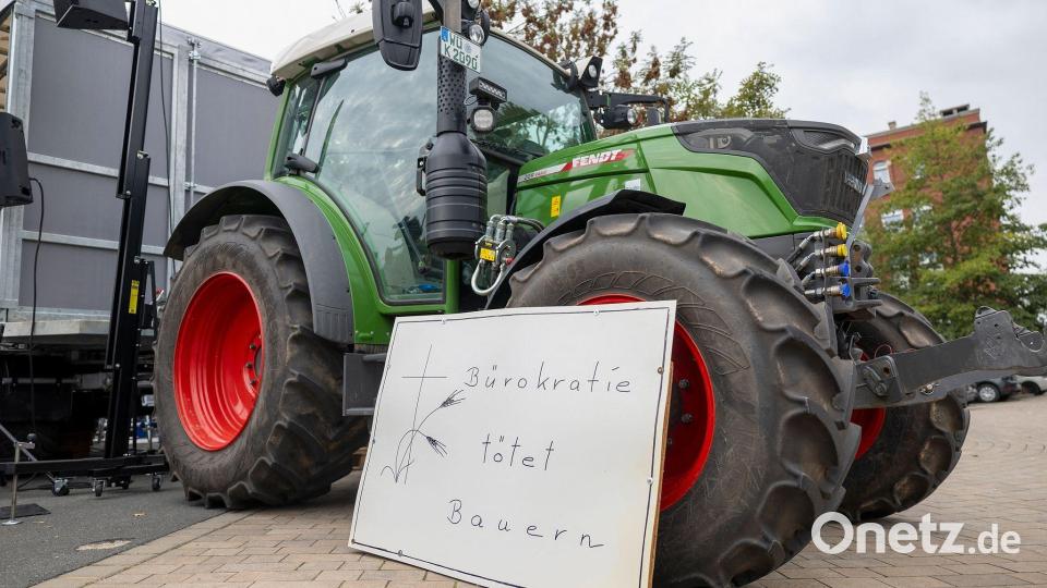 „Bürokratie tötet Bauern“ steht auf einem Schild vor einem Traktor bei einer Kundgebung am Rande der Agrarministerkonferenz. Bild: Heiko Becker/dpa