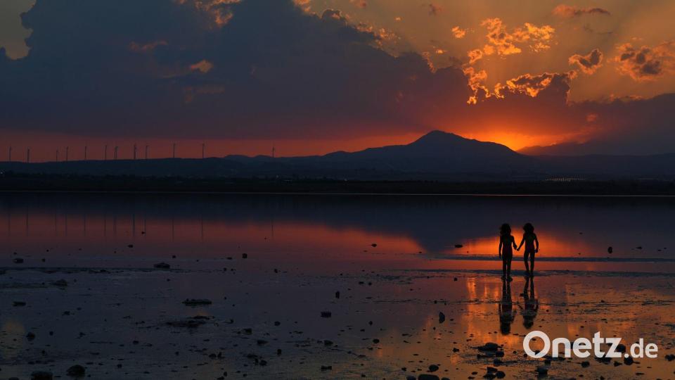 Zwei Mädchen spielen bei Sonnenuntergang am Salzsee in der südlichen Küstenstadt Larnaca auf Zypern. Bild: Petros Karadjias/AP/dpa