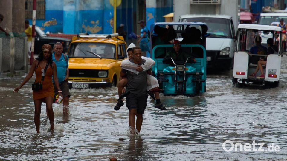 Havanna, Kuba: Nach Regenfällen steht die Straße kniehoch – Menschen waten durch die Fluten Bild: Ramon Espinosa/AP/dpa