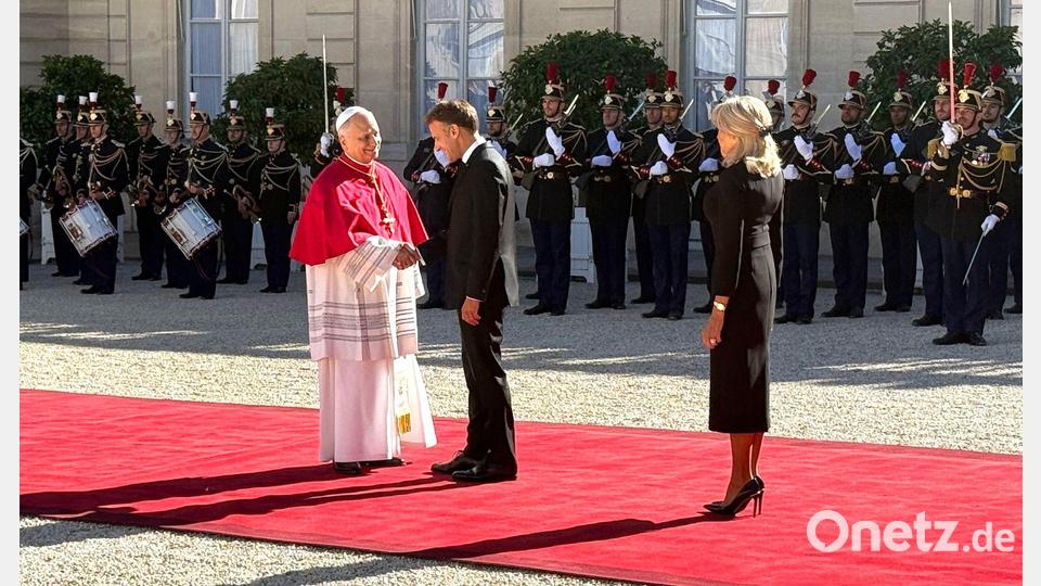 Frankreichs Präsident Emmanuel Macron und seine Ehefrau Brigitte schütteln Hände mit dem Papst im Hof des Élysée-Palastes. Bild: Christoph Sator/dpa