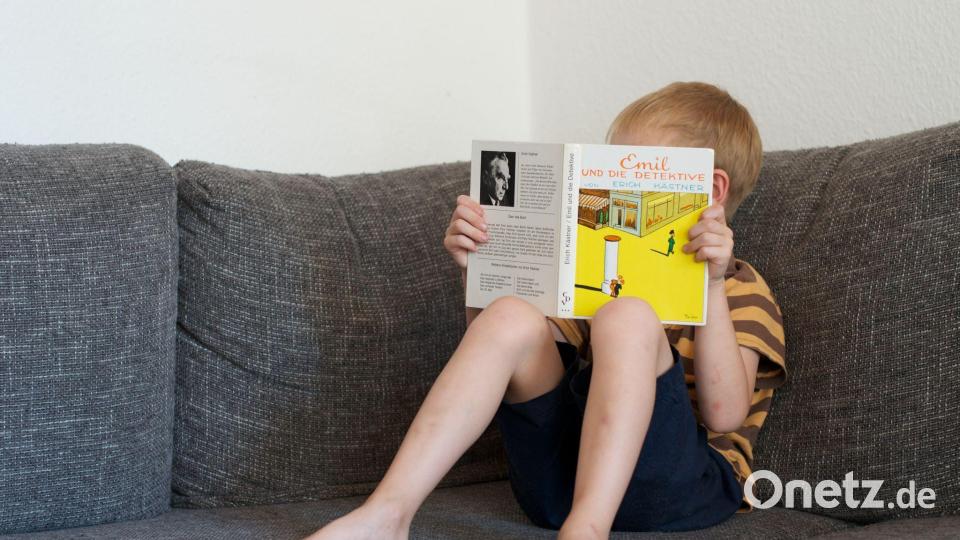 Ein Junge liest das Buch „Emil und die Detektive“ von Kästner. (Archivbild) Bild: picture alliance / dpa