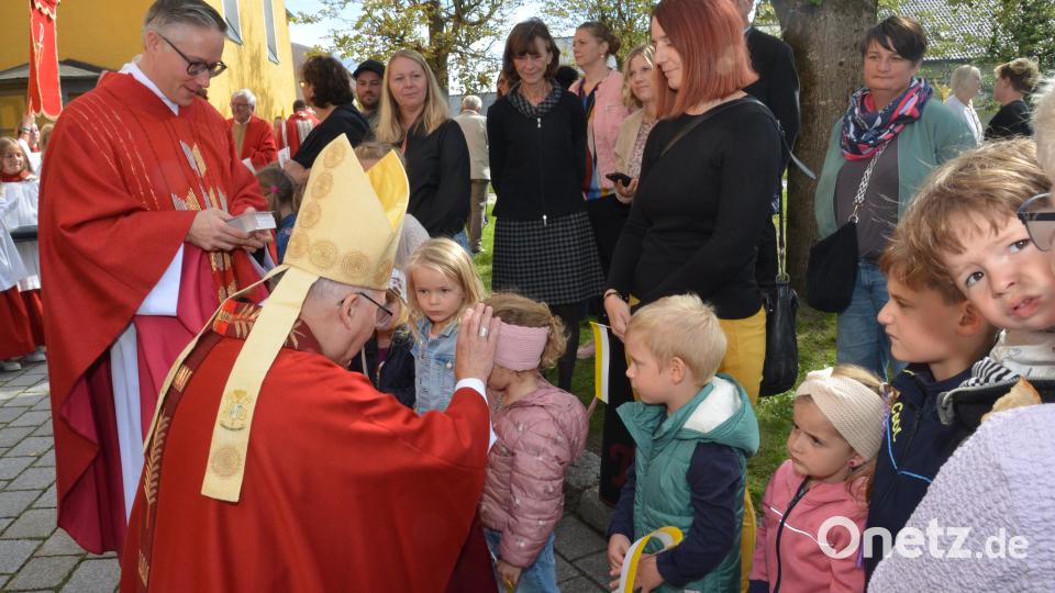 Viele Buben und Mädchen des Kindergartens St. Emmeram waren zum Kirchenportal mit gelb-weißen Kirchenfähnchen gekommen, um sich vom Bischof segnen zu lassen. Bild: Elisabeth Dobmayer