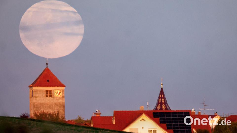 Während der Römerturm in Emerkingen von der Abendsonne angestrahlt wird, geht hinter ihm der Vollmond auf. Bild: Thomas Warnack/dpa