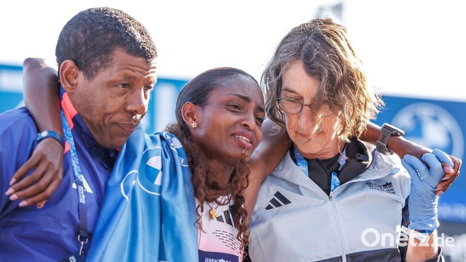 Tigst Assefa musste mit Tränen in den Augen von Lauf-Legende und ihrem Trainer Haile Gebrselassie im Ziel gestützt werden. Bild: Andreas Gora/dpa