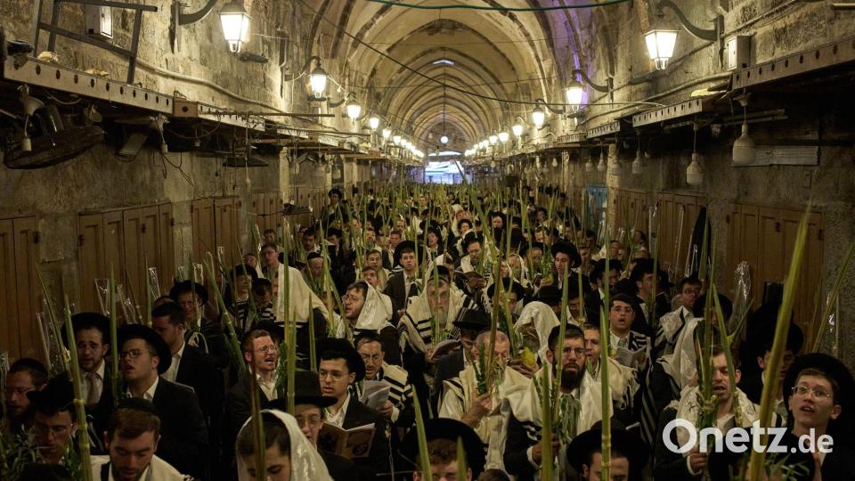 Orthodoxe jüdische Männer beten während der Morgengebete zum jüdischen Laubhüttenfest (Sukkot) vor dem Tor des Souq Al-Qattanin. Bild: Leo Correa/AP/dpa