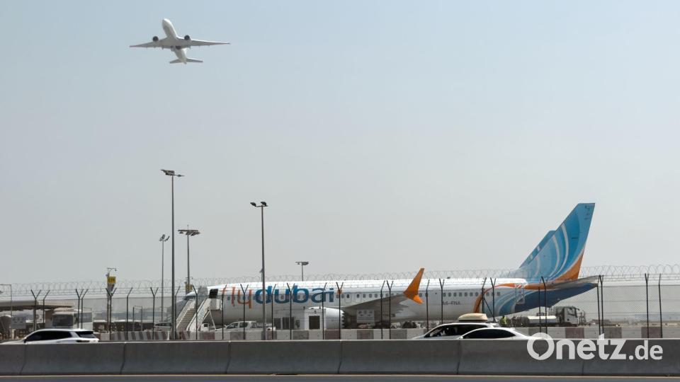 Ein Flugzeug hebt ab, während ein Flydubai-Flieger in Dubai auf dem Flughafen steht. Bild: Uncredited/AP/dpa