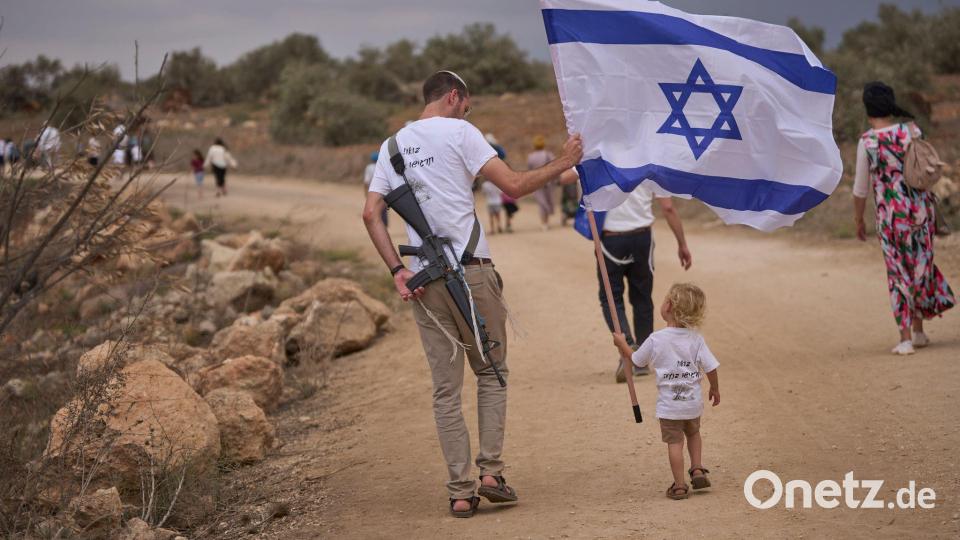 Israelische Siedler gehen auf der Straße zwischen Ganim und Kadim entlang, um die Einweihung des neu errichteten illegalen Außenpostens Kadim im besetzten Westjordanland zu feiern. Bild: Ohad Zwigenberg/AP/dpa