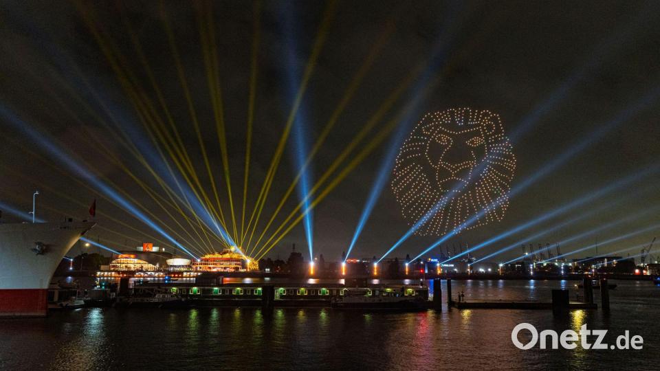 Eine Drohnenshow anlässlich des 25-jährigen Jubiläums von "Der König der Löwen" illuminiert mit Figuren des Musicals den Hamburger Hafen. Bild: Markus Scholz/dpa