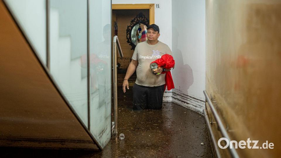 Ein Mann steht im Treppenhaus eines Gebäudes in der an Barcelona grenzenden Stadt L'Hospitalet de Llobregat in mehr als knietiefem Wasser. Bild: Lorena Sopêna/EUROPA PRESS/dpa