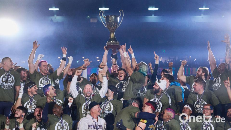 Headcoach Greag Seamon von den Dresden Monarchs und seine Mannschaft jubeln nach dem Sieg gegen die Potsdam Royals mit dem Pokal. Bild: Robert Michael/dpa
