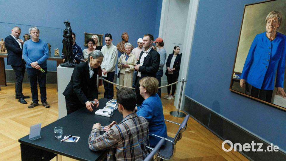 Im Bode-Museum signierte Merkel am Nachmittag Kunstpostkarten gemeinsam mit dem Maler ihres Porträts. Bild: Carsten Koall/dpa