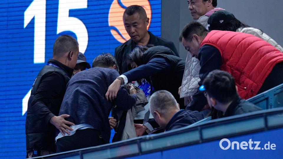 Helfer kümmern sich um einen Mann, der von einem Ball verletzt wurde, den der Russe Medwedew in die Zuschauerränge geschlagen hatte. Bild: Andy Wong/AP/dpa
