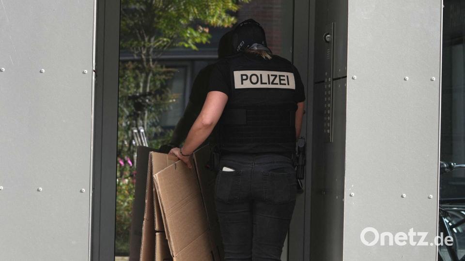In Berlin tragen Polizisten leere Umzugskartons in ein Gebäude. Unter der Adresse ist laut Handelsregister eine Vermögensverwaltungsgesellschaft eingetragen, als persönlich haftender Gesellschafter wird dort Ex-BND-Präsident August Hanning geführt. Bild: Sven Kaeuler/dpa