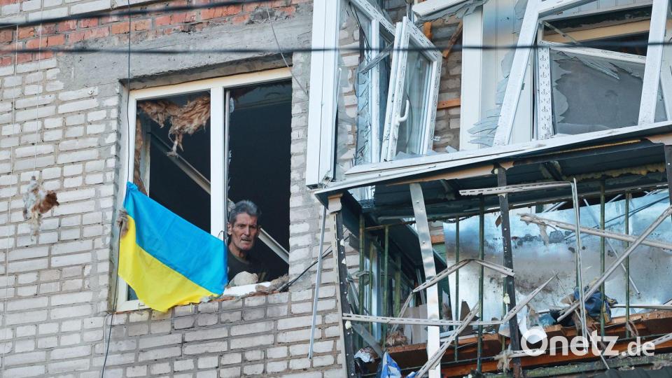 Mann blickt durch ein zerbrochenes Fenster in Saporischschja nach russischem Angriff Bild: Kateryna Klochko/AP/dpa