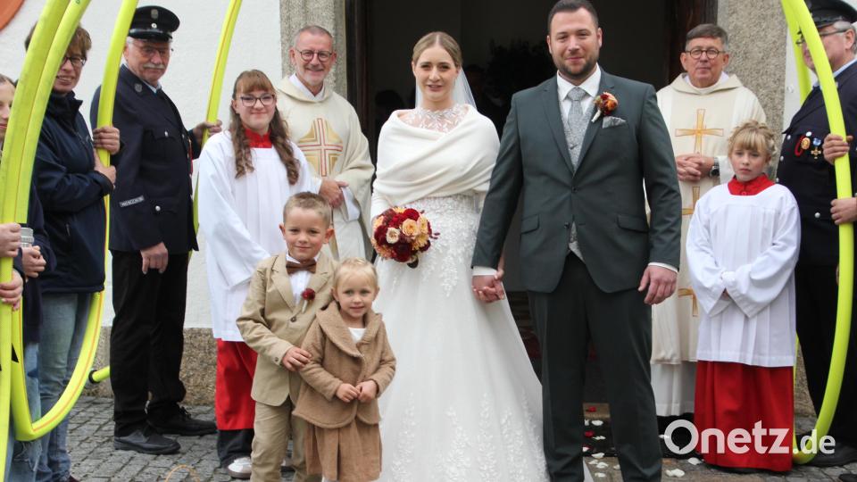 Freudestrahlend verlassen Veronika und Andreas Häckl die Kappl-Kirche, mit dabei waren die beiden Brautkinder Fanni und Quirin. Im Hintergrund Stadtpfarrer Thomas Vogl (links) und Pater Otto Grillmeieer (rechts). Bild: Konrad Rosner