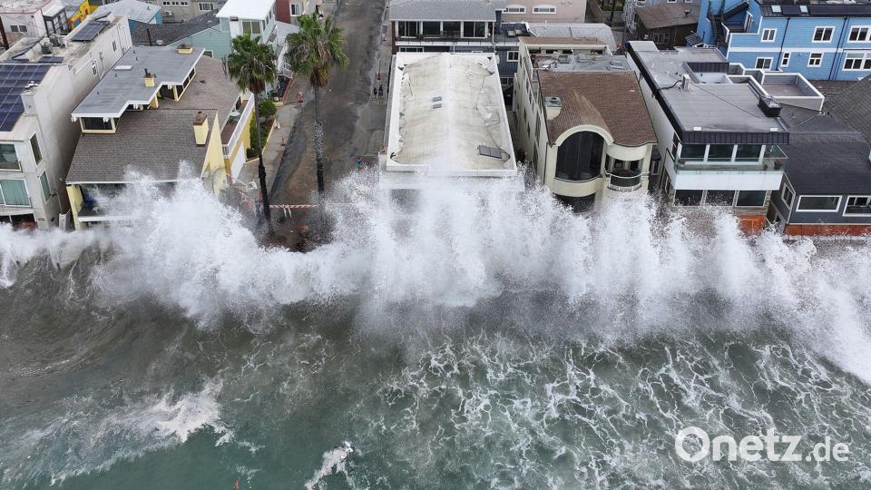Wellen treffen auf einen einen Gehweg vor einigen Häusern in Long Beach, während sich der Tropensturm „Rachel“ nähert. Bild: William Liang/AP/dpa