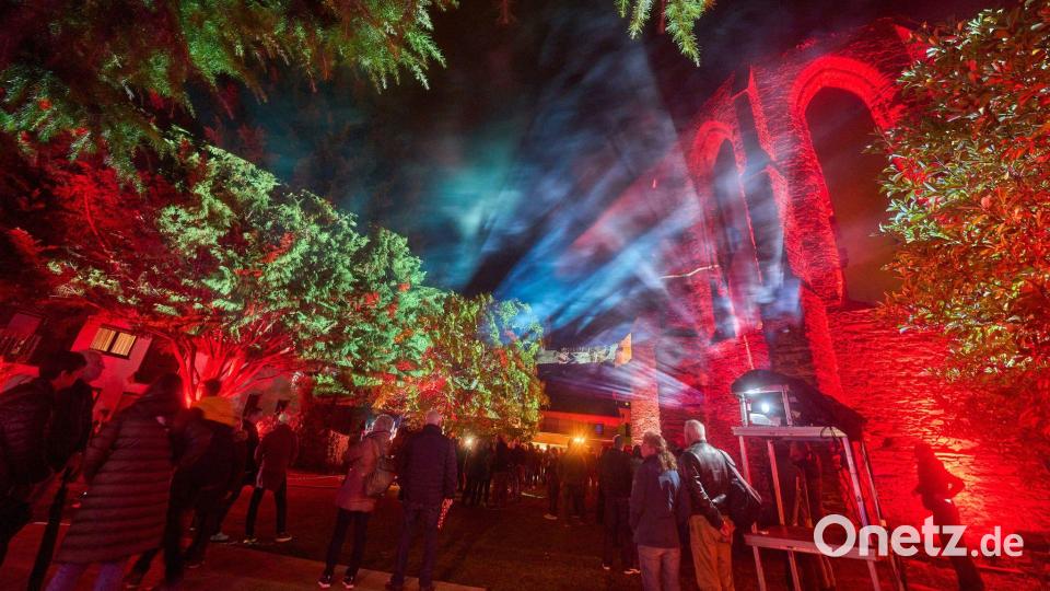 Besucher des Lichtkunstfestival Rheinleuchten wandeln durch den illuminierten Klostergarten in Oberwesel. Bild: Thomas Frey/dpa