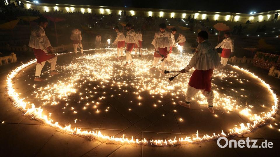 Menschen in traditioneller Tracht führen während der neuntägigen Feierlichkeiten des hinduistischen Festes Navratri in Ahmedabad in Indien den „Mashal Raas“ auf. Bild: Ajit Solanki/AP/dpa