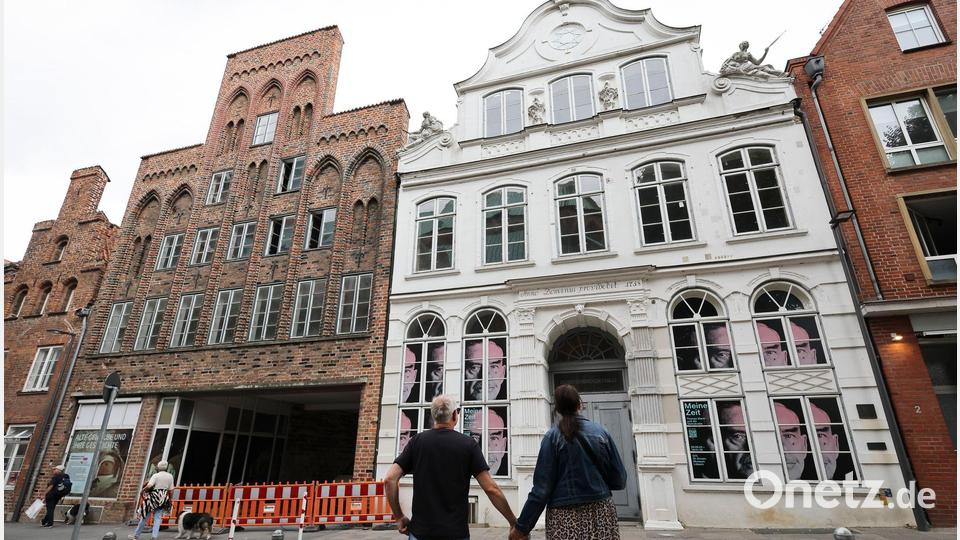 Passanten betrachten das geschlossene Buddenbrookhaus in der Lübecker Altstadt. Bild: Christian Charisius/dpa