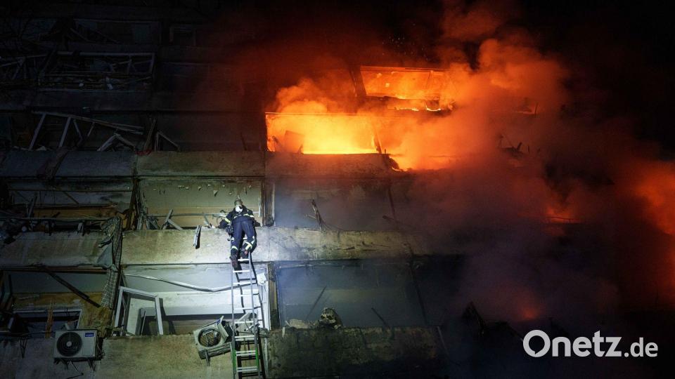 Eine Rettungskraft klettert in Kiew eine Leiter hinauf. Bild: Evgeniy Maloletka/AP/dpa
