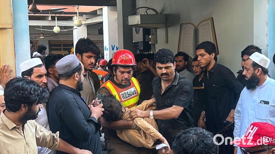 Ein Helfer trägt ein verletztes Kind, das er es aus den Trümmern geborgen hat. Bild: Arif Khan/AP/dpa