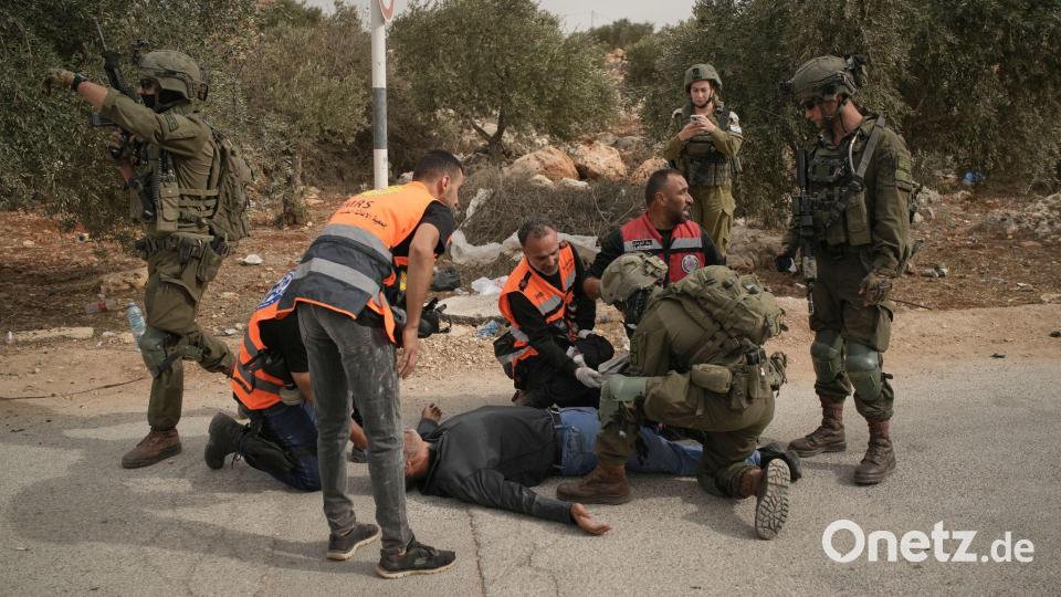 Palästinensische Sanitäter und ein israelischer Soldat kümmern sich um einen palästinensischen Mann, der von israelischen Soldaten angeschossen wurde. Bild: Leo Correa/AP/dpa