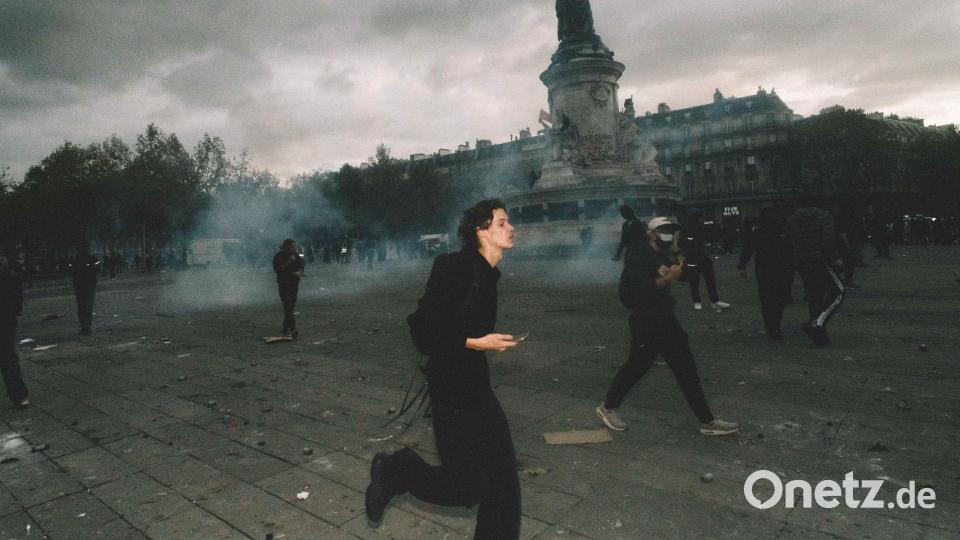 Demonstranten rennen über den Place de la République, während in Paris Tränengas in der Luft hängt. Bild: Fabian Suspensivo/ZUMA Press Wire/dpa