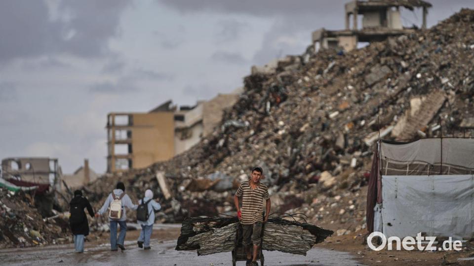 Palästinenser trägt Bleche durch Kriegsschutt in Gaza Bild: Jehad Alshrafi/AP/dpa