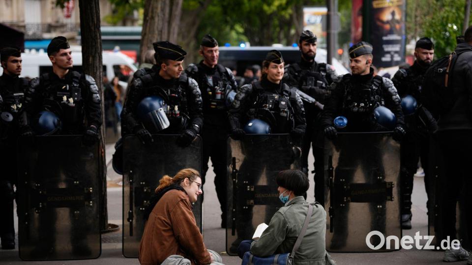 Schüler sitzen bei einem Protest gegen schlechte Bildungsbedingungen an Schulen vor Polizisten. Bild: Teresa Suarez/AP/dpa