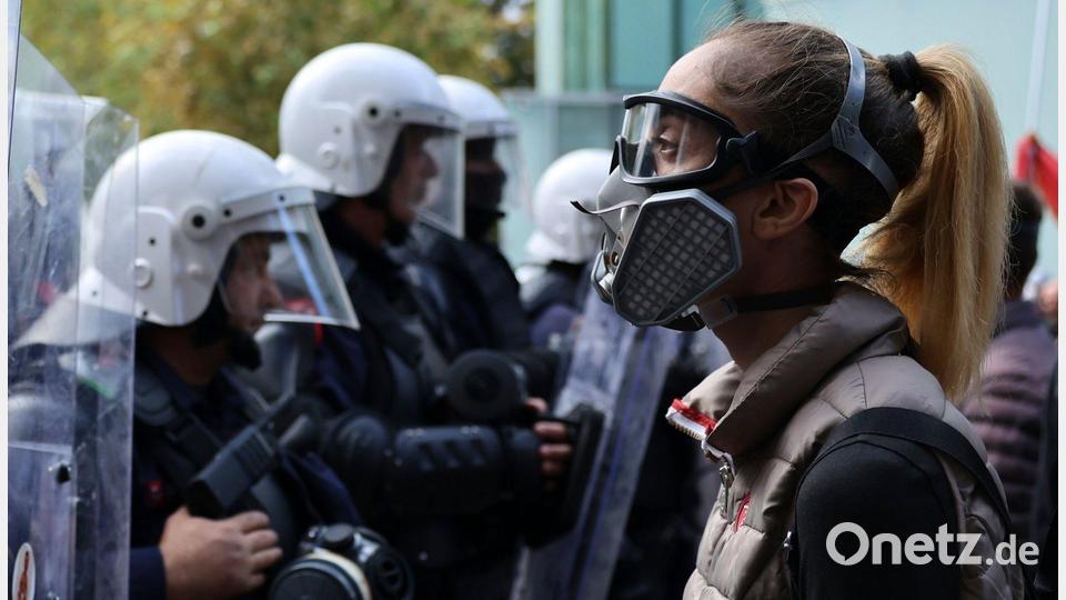 Eine Demonstrantin trägt Schutzausrüstung während einer regierungskritischen Demonstration in Tirana. Bild: Hameraldi Agolli/AP/dpa