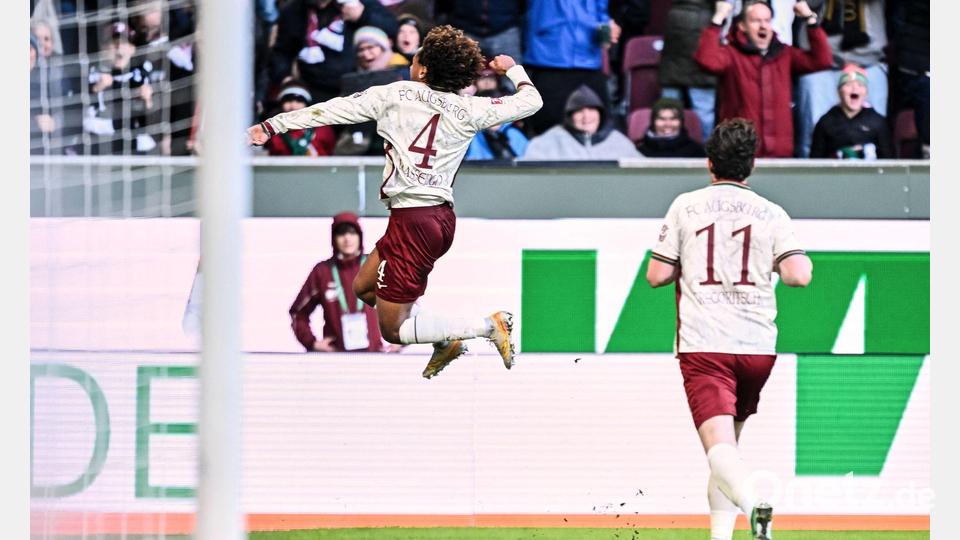 Han-Noah Massengo hebt nach seinem 1:0 jubelnd ab - zum Sieg reichte sein Kopfballtor für den FC Augsburg aber nicht. Bild: Harry Langer/dpa