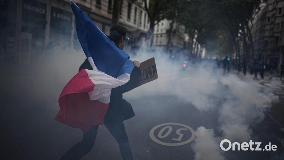 Ein Demonstrant hält während einer Demonstration in Lyon gegen steigende Lebenshaltungskosten eine französische Flagge. Bild: Laurent Cipriani/AP/dpa