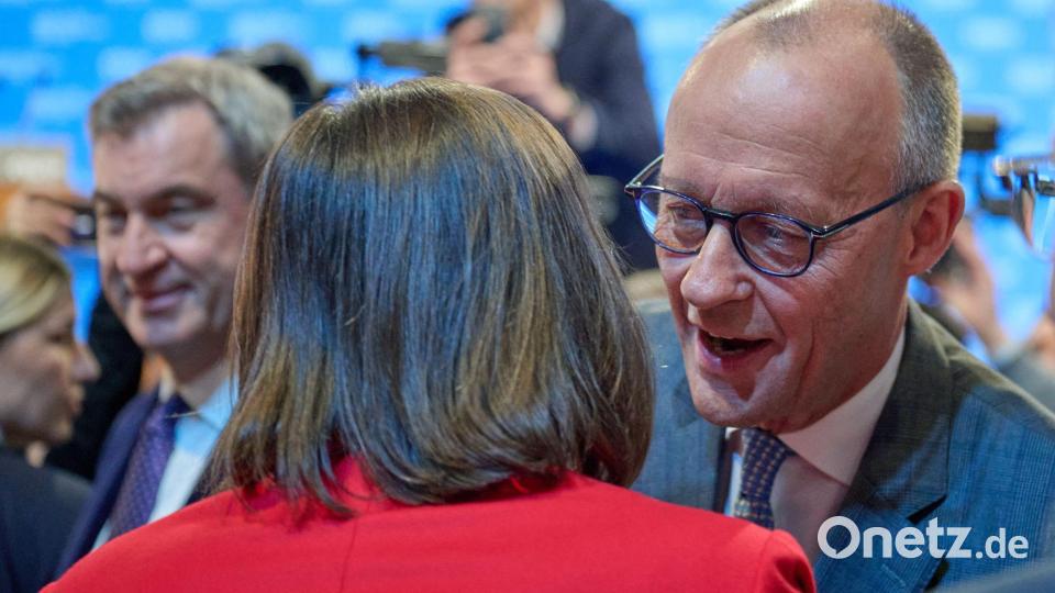 Friedrich Merz begrüßt Ilse Aigner mit Wangenküsschen. Bild: Peter Kneffel/dpa