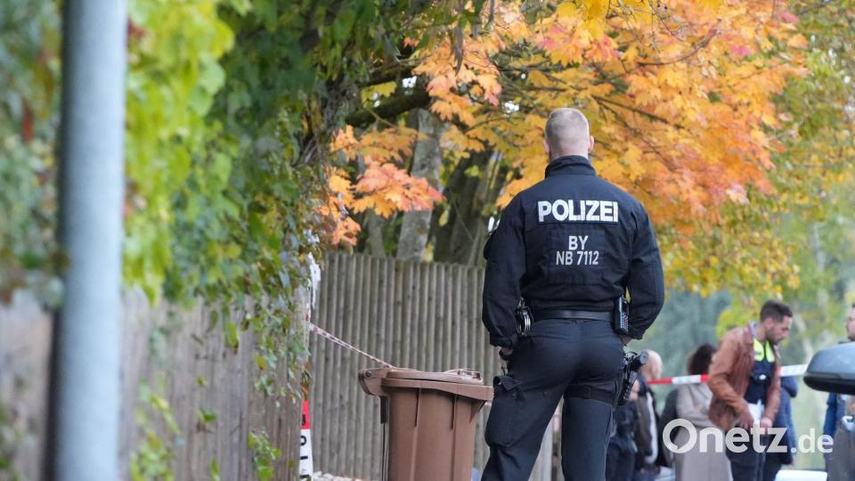 Einsatzkräfte der Polizei stehen im Landkreis Dingolfing-Landau vor einem Wohngebäude auf der Straße. Ein 43 Jahre alter Mann ist nach Polizeiangaben beim Öffnen seiner Haustür von einem Unbekannten erschossen worden. Bild: Felix Kirberg/dpa