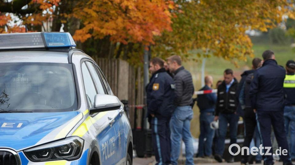 Einsatzkräfte der Polizei stehen nach einem Schusswechsel im Landkreis Dingolfing-Landau vor einem Wohngebäude auf der Straße. Ein 43 Jahre alter Mann ist nach Polizeiangaben beim Öffnen seiner Haustür von einem Unbekannten erschossen worden. Bild: Felix Kirberg/dpa