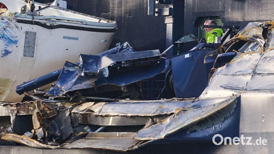 Zwei Männer begutachten den Schaden an der „Mein Schiff 3“. Das Kreuzfahrtschiff war am Vortag bei stürmischem Wetter mit zwei Containerschiffen kollidiert. Bild: Sina Schuldt/dpa