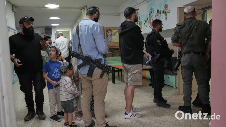 Israel-Wahl: Bewaffnete Siedler warten am Wahllokal Bild: Leo Correa/AP/dpa