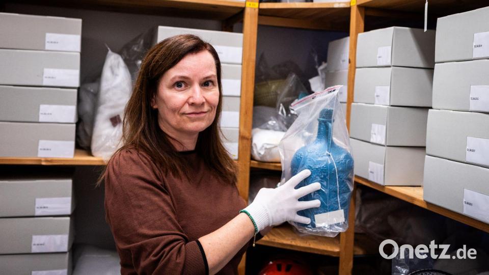 Bengü Kocatürk-Schuster vom Dokumentationszentrum und Museum über die Migration in Deutschland (DOMiD) zeigt eine Trinkflasche, die von Türken einst auf ihre erste Reise nach Deutschland mitgenommen wurde. Bild: Christian Knieps/dpa