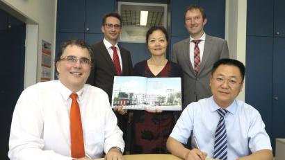 BBZ-Leiter Michael Mändl (links) und Headmaster Zhao Yong (rechts) unterzeichneten einen Vertrag für die künftige Zusammenarbeit. Mit dabei waren IHK-Bereichsleiter Ralf Kohl, Ausbildungsleiterin Jian Song und der stellvertretende Geschäftsführer der Arbeitsagentur, Bernhard Lang (stehend von links).	Bild: Hirsch