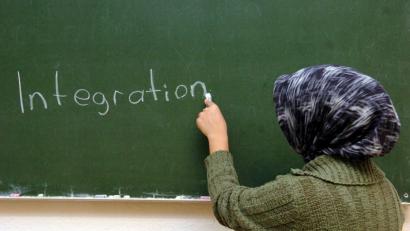 Eine türkische Frau schreibt im Schulungsraum einer interkulturellen Frauenbegegnungsstätte in Hamburg an die Tafel. 	Bild: Patrick Lux/dpa