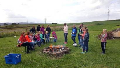 Im Garten von Sandra Rewitzer-Stengel erfuhren die Mädchen und Buben viel Wissenswertes über Kräuter und ihre Verwendung. Über einem Lagerfeuer durften sie in einer Pfanne Brennnesselblätter, die in Pfannkuchenteig getaucht wurden, braten.	Bild: tu