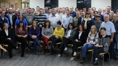 Novem-Geschäftsführer Johannes Burtscher (rechts, stehend), Konzernleiterin für Personal, Claudia Bahmann (sitzend, Erste von links), Janine Kiesl aus der Personalabteilung (sitzend, Zweite von links) sowie Bernd Meyer (erste Reihe, stehend, links), Werksleiter der Standorte Vorbach und Kulmbach, sind stolz darauf, langjährige Mitarbeiter des Betriebs ehren zu können.	Bild: ilt