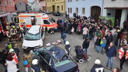 Die Feuerwehr hofft auf viele Zuschauer  bei ihrer Schauübung. Sie wird nicht enttäuscht. An der Seite von Thomas Schmidt (rechts) moderiert Kommandant Markus Schwarz (links daneben, mit Mikrofon) durch die Szenerie. 	Bild: fjo