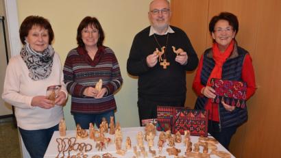 Rita Thoma, Margit Wild, Stadtpfarrer Anton Witt und Frauenbund-Vorsitzende Stilla Schuller (von links) zeigen einen Teil der Schnitzereien und Taschen, die am Samstag beim Weihnachtsmarkt verkauft werden.	Bild: jr