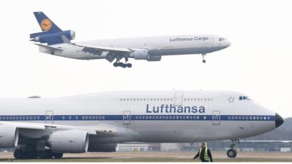 Eine MD-11F der Lufthansa-Cargo landet auf dem Frankfurter Flughafen. Im Vordergrund eine Lufthansa Boeing 747-8 im Retrolook. 	Bild: Arne Dedert/dpa