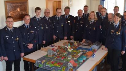 Kreisbrandinspektor Lorenz Müller (Siebter von links) und Kreisbrandrat Andreas Wührl (Achter von links) besprechen mit den Teilnehmern des Lehrgangs Einsatztaktik bei Planspielen unter anderem die Fahrzeugaufstellung und das taktische Vorgehen bei größeren Bränden. 	Bilder: mde (2)