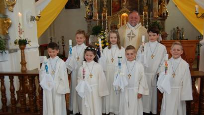 Sieben Kinder feiern in der Pfarrkirche in Michldorf mit Pfarrer Alfons Forster Erstkommunion. 	Bild: grm