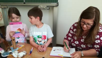 Nach der Lesung erfüllt Autorin Usch Luhn die Signierwünsche der Kinder. 	Bild: hmp