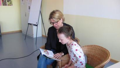 Kinderbuchautorin Alexandra Fischer-Hunold holte sich für ihre Lesung vom "Gespenst im Klassenzimmer" Schüler und Schülerinnen (hier Laura) zur Unterstützung die stolz auf ihre Lesekünste nach nur kurzer Schulzeit waren.