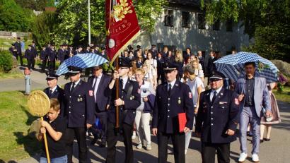 Die Feuerwehrführung mit den Festdamen, -kindern und Mitgliedern auf dem Weg zum Schirmherrn. Die Ehrenschirmherren Günther Holler und Gerald Reiter hatten bereits die Insignien, einen weiss-blauen Regenschirm, erhalten.